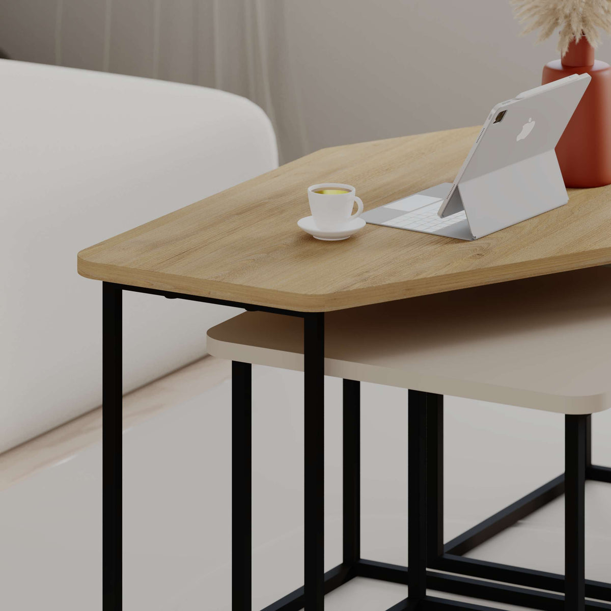 Set of modern nesting coffee tables with black metal legs and particle board tops, perfect for flexible living room use.