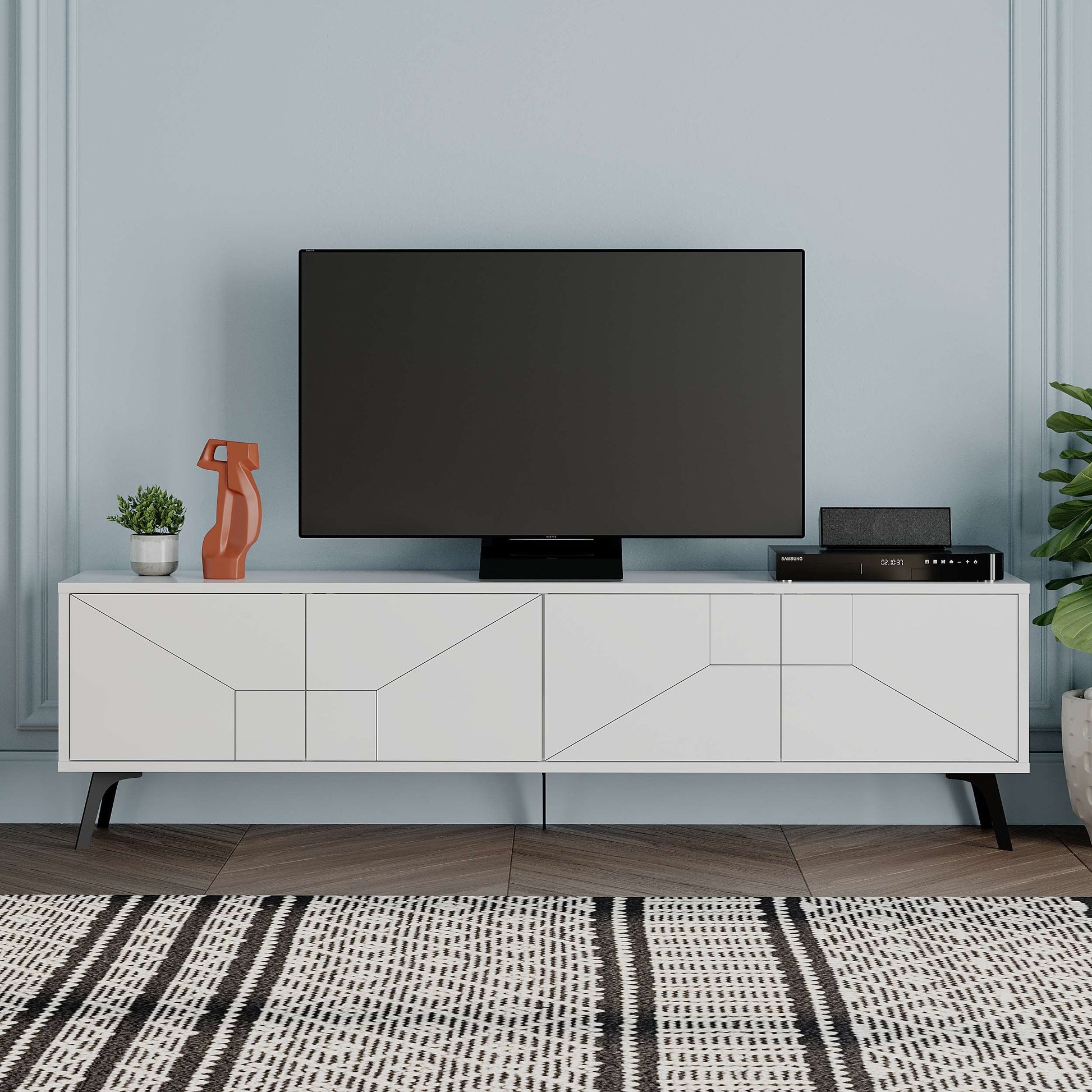 Modern TV stand with geometric pattern doors, raised metal legs, and concealed media storage.